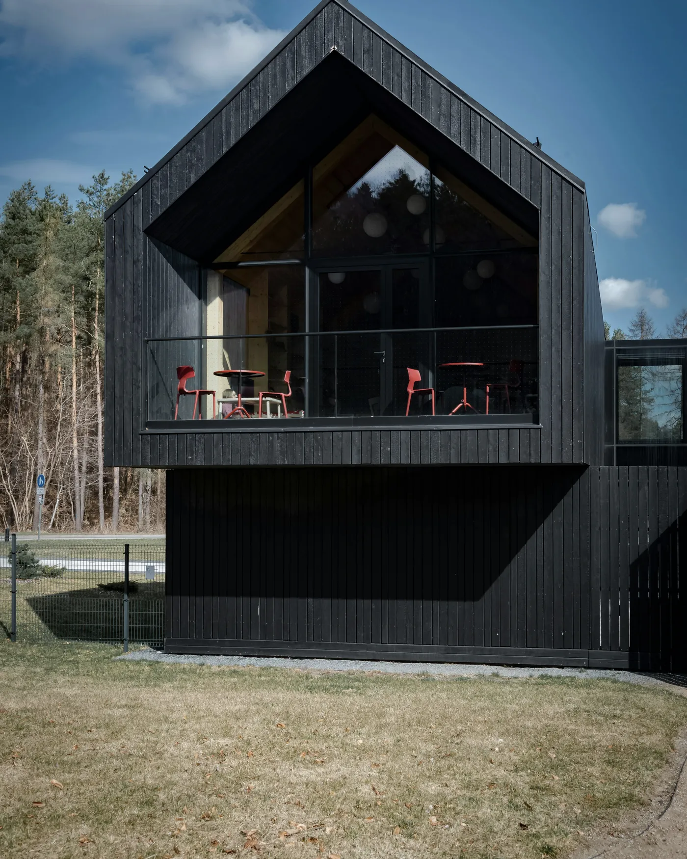 Façade en bois sombre et grandes baies vitrées