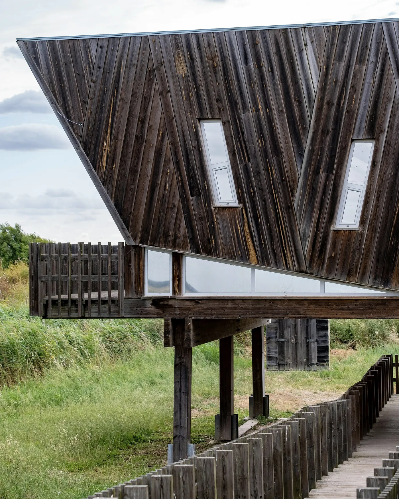 Bardage en bois brut et fenêtres toute hauteur
